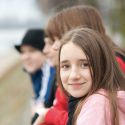 Closeup of a smiling middle school girl with 3 friends at the beach