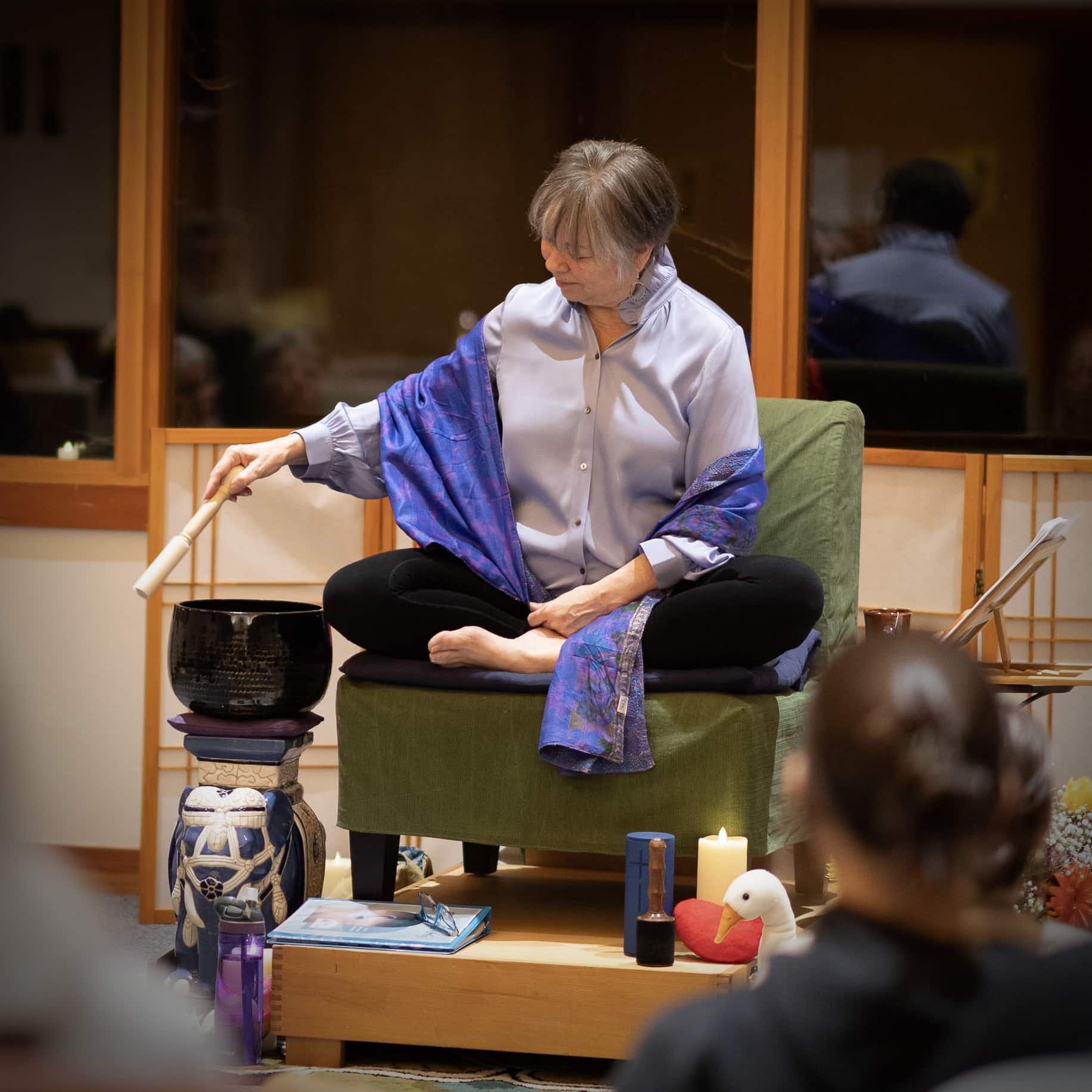 Meditation teacher ringing a bell at a retreat