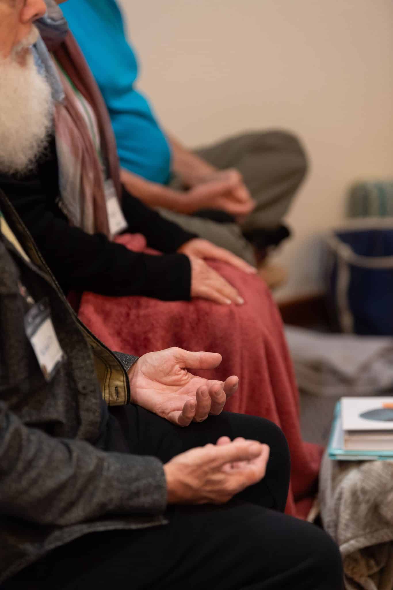 Closeup of people's hands in meditation mudras