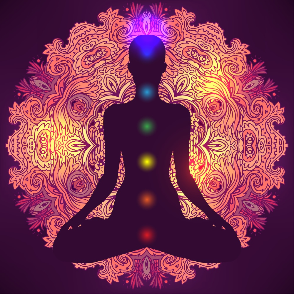 Woman ornate silhouette sitting in lotus pose. Meditation, aura and chakras.