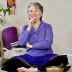 Woman seated on a meditation cushion.